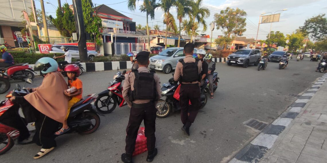 Sat Samapta Polres Bontang Membagikan Makanan Siap Saji di Simpang 3 Ramayana